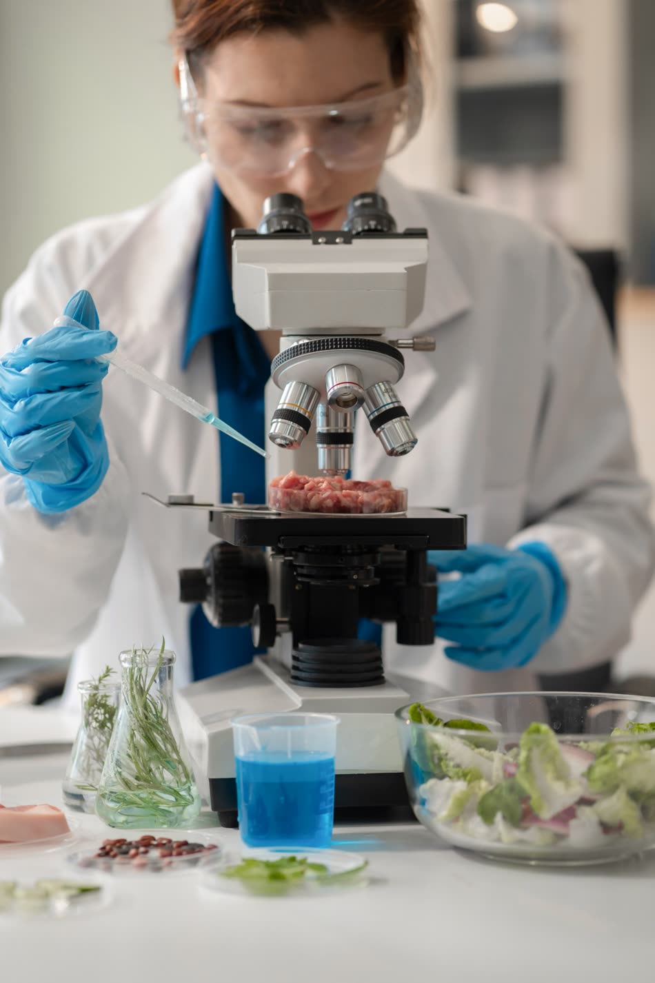 Analista revisando una muestra cárnica al microscopio